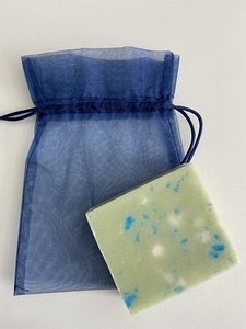 Körper-, Haar- und Rasierseife „Globetrotter“ liegt auf einem blauen Organzasäckchen